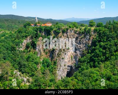 Blick auf die tiefe Schlucht des Flusses Reka und Dorf mit ländlichen Kirche, Skocjan Höhlen, Slowenien Stockfoto