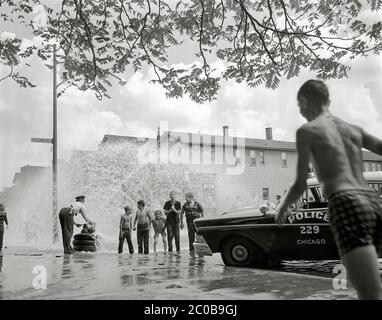 Die Polizei hat den Hydranten abgeschaltet, der den Spaß für Kinder in den Straßen von Chicago 1959 stoppt. Bild von 4x5 Zoll Negativ. Stockfoto