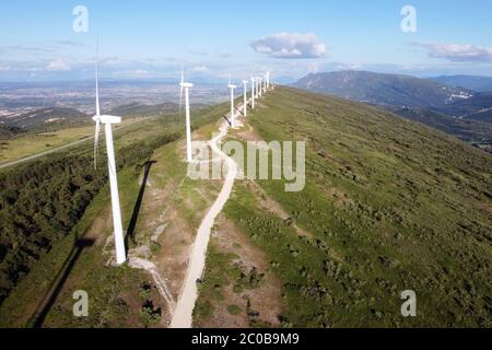 Luftaufnahme der Windmühlen Farm für erneuerbare Energien Produktion auf schönen blauen Himmel. Windkraftanlagen erzeugen saubere erneuerbare Energie für eine nachhaltige Entwicklung. Hochwertige 4k-Aufnahmen. Stockfoto