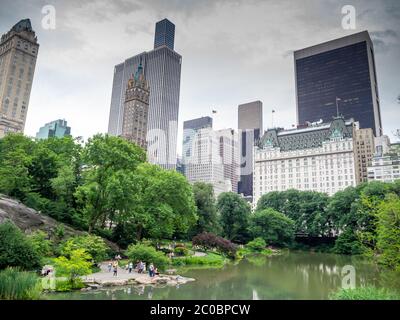 New York Uptown Wolkenkratzer vom Central Park Teich mit Touristen im späten Frühjahr gesehen Stockfoto