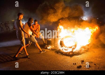 Beirut, Libanon. Juni 2020. Menschen Rollen Reifen in ein Feuer, während sie am 11. Juni 2020 in Beirut, Libanon, protestierten. Die Menschen protestierten, als der libanesische LiraÃs-Wert auf 5,000 L.L. pro 1 Dollar fiel, wobei einige Demonstranten sagten, er sei auf 7,000 L.L. pro 1 Dollar gefallen. Kredit: Daniel Carde/ZUMA Wire/Alamy Live News Stockfoto