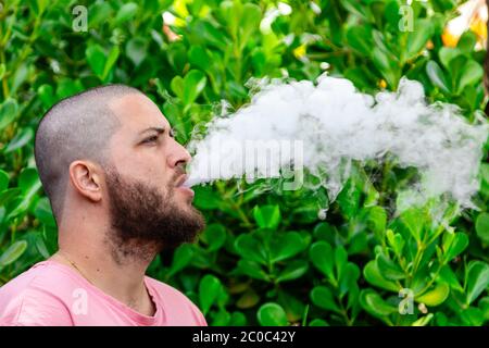 Kahlköpfiger und bärtiger Mann, der raucht. Stockfoto