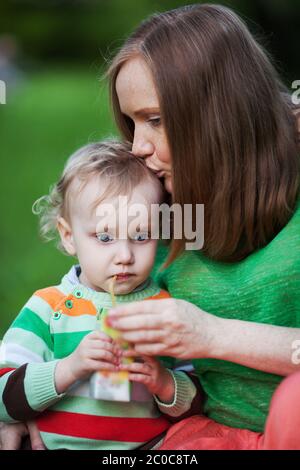 Mutter das Kind trinken Saft outdoor küssen Stockfoto