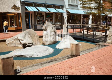 Boulder, Colorado - 27. Mai 2020: Kinderspielplatz mit Kletterfelsen und Fußgängerbrücke in der Pearl Street Mall. Stockfoto