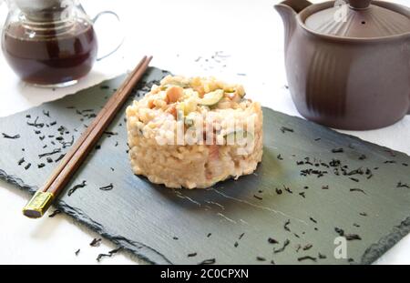 Risotto in Tee mit Zucchini gekocht, geräuchert, Käse und Speck Stockfoto