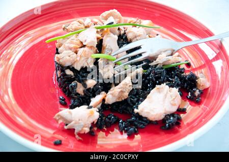 Schwarzer Reis mit Lachs Sahne und Petersilie Stockfoto