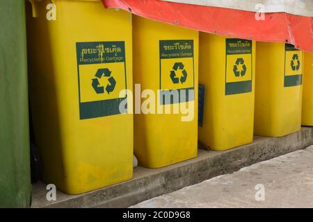 Nahaufnahme und selektiver Fokus der Reihe von Mülltonnen mit recyclebaren Müll Zeichen in englisch und thai, auf Zementboden in der Nähe Müllraum stehen Stockfoto