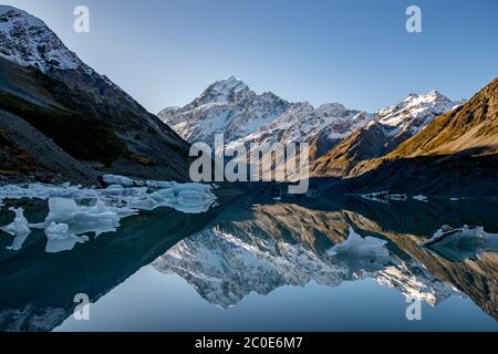 Erstaunliche Reflexionen von Mt Cook und den Eisbergen, die auf Hooker Glacial Lake im Aoraki Mt Cook National Park schweben Stockfoto