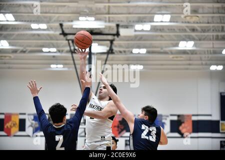 Spieler, der einen Sprung zwischen und über ein Paar Verteidiger freigibt. USA. Stockfoto