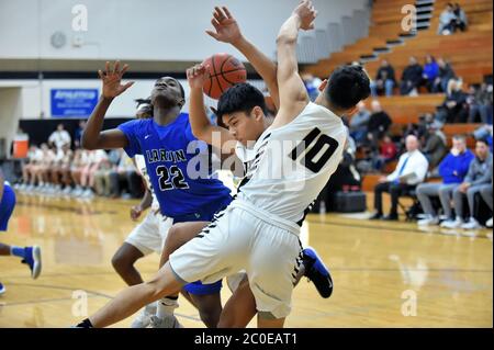 Spieler gefangen in der Mitte eines drei-Mann-Kollision unter dem Korb. USA. Stockfoto