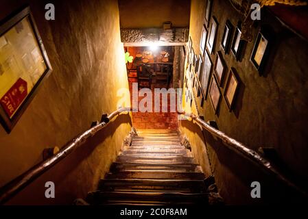 VILLA GESELL, ARGENTINIEN, 14. NOVEMBER 2019: Dramatische Sicht auf die schaurige Treppe von oben in die Dunkelheit des Innenraums des alten Pubs Stockfoto