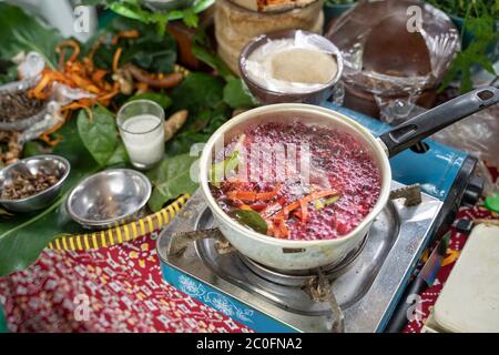 Kochen traditionelle Kräutermedizin Wedang uwuh, rot-gefärbte gekochtes Wasser aus secang Holzspäne Stockfoto