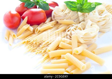 Nudeln in verschiedenen Größen mit Tomaten und Basilikum Stockfoto