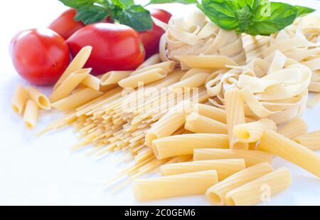 Nudeln in verschiedenen Größen mit Tomaten und Basilikum Stockfoto