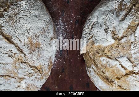 Frisch gebackenes hausgemachtes Brot in Korbkorb auf Holztisch Stockfoto