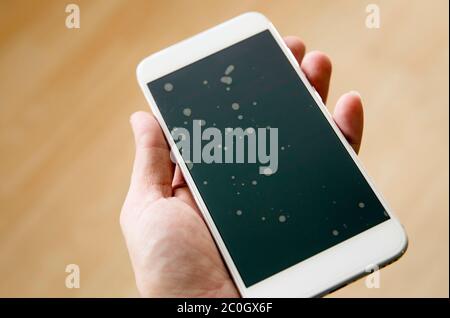 Schlecht installierte Smartphone-Schutz-Bildschirm Glasschicht mit Staubpartikeln zwischen Schutzglas und Touchscreen. Stockfoto