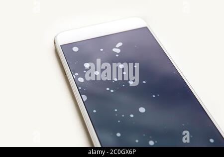 Schlecht installierte Smartphone-Schutz-Bildschirm Glas mit Staubpartikeln zwischen Schutzglas und Touchscreen. Stockfoto