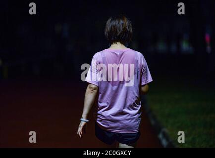 Haikou, Chinas Provinz Hainan. Mai 2020. Eine Frau macht einen Spaziergang nach ihrem Nachtlauf in Haikou, südchinesische Provinz Hainan, 20. Mai 2020. Night Run ist ein beliebter Sport unter den Bürgern in Haikou geworden. Quelle: Pu Xiaoxu/Xinhua/Alamy Live News Stockfoto