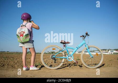 Nettes kleines Mädchen schießen auf dem Land mit ihrem Instant-Bild Fotokamera. Sie hat ein schönes Retro-Fahrrad an der Seite geparkt Stockfoto