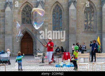 Zürich, Schweiz - 6. Oktober 2018: Glückliche Kinder, die Spaß an einer Seifenblasenshow haben, die von einem lokalen Straßenkünstler zur Unterhaltung aufgeführt wird. Stockfoto