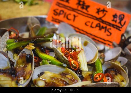 Teller mit würzigen Muscheln auf einem Nachtmarkt in Hong Kong China verkauft Stockfoto