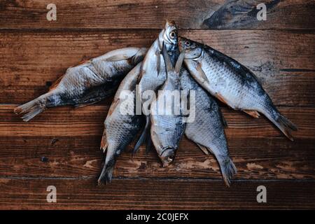 Salziger trockener Flussfisch auf dunklem Holzhintergrund. Trockener Fisch auf dem Markt. Street Food. Stockfoto