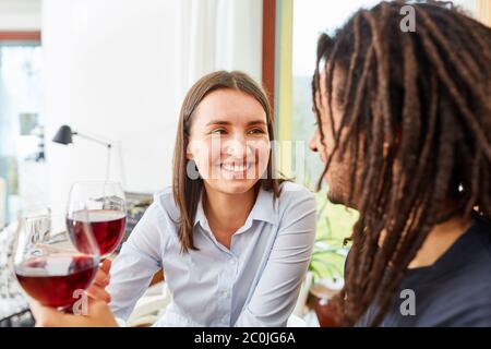 Glückliches Paar trinkt Rotwein zusammen zu Hause mit einem Gespräch Stockfoto