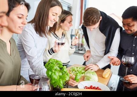 Gruppe von Freunden in der Küche Schneiden Salat für eine Mahlzeit zusammen Stockfoto