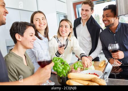 Gruppe von Freunden, die in der Gemeinschaftsküche miteinander reden und gemeinsam essen Stockfoto