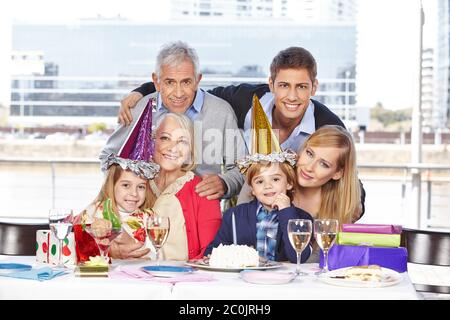 Glückliche Familie feiert den Geburtstag des Sohnes mit den Großeltern Stockfoto