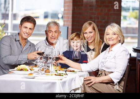 Familie im Restaurant zum Mittagessen Toast mit Rotwein Stockfoto