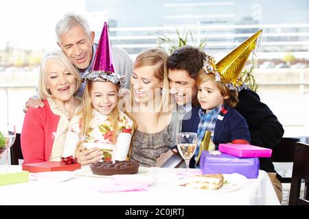 Glückliche harmonische Familie feiert den Kindergeburtstag der Tochter mit den Großeltern Stockfoto