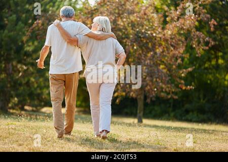 Zwei Senioren gehen im Sommer zu einem Spaziergang in der Natur Stockfoto