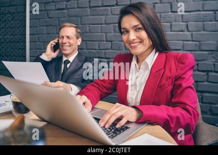 Attraktive junge Managerin, die ihre Finger auf der Tastatur hält Stockfoto