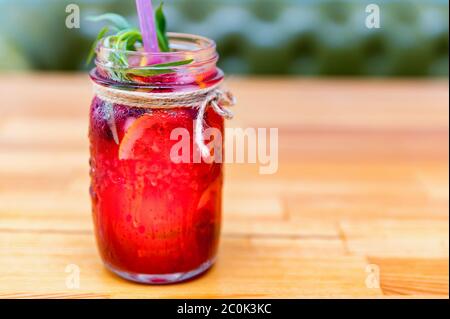 Eine Flasche hausgemachter Limonade oder Mojito Cocktail mit Zitrone, Limette und Himbeere, kaltes Erfrischungsgetränk oder Getränk mit Eis. Nahaufnahme. Selektiver Fokus Stockfoto