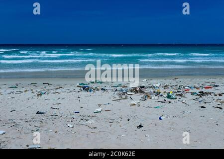 Plastikflaschen und anderer Müll, der auf die Sandküste geworfen wird, Müll am Meeresstrand, ökologisches Problem. Umweltverschmutzung. Schmutziger Sandstrände Stockfoto