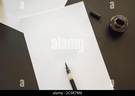 MOCKUP, SZENENBILDSTELLER Kalligraph Junge Frau schreibt Phrase auf weißem Papier. Beschriftend dekorativ verzierte Buchstaben. Kalligraphie, Grafikdesign Stockfoto