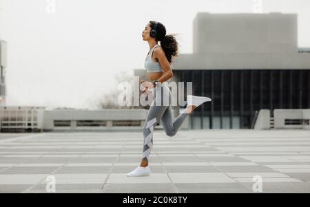 Ganzkörperaufnahme einer gesunden Frau, die in der Stadt läuft. Sportliche Frau in der Stadt trainieren. Stockfoto