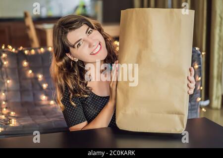 MOCKUP, SZENE SCHÖPFER Frau hält Papiertüte inmitten eines Stapels von Plastiktüten. Zero Waste Konzept. Das Konzept des Weltumwelttages Stockfoto