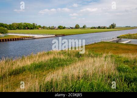 Der Kanal, der die Spitze eines modernen Aquädukts bildet, kreuzt die Straße, auf der der Verkehr unterwegs ist. Bild aufgenommen in der Provinz Friesland, Region Gaasterland Stockfoto