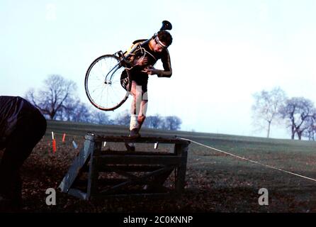 Cyclo-Cross-Konkurrent, der 1976 bei einem Rennen auf Reigate Hill Fahrrad über Rampe trägt Stockfoto