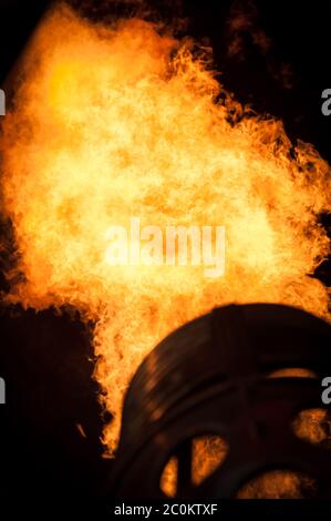 Flammen in der Nacht zu einem Heißluftballon erwärmen. Stockfoto