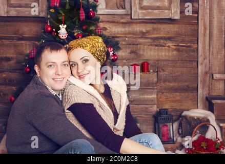 Paar lachen zusammen in der Nähe des Weihnachtsbaums Stockfoto