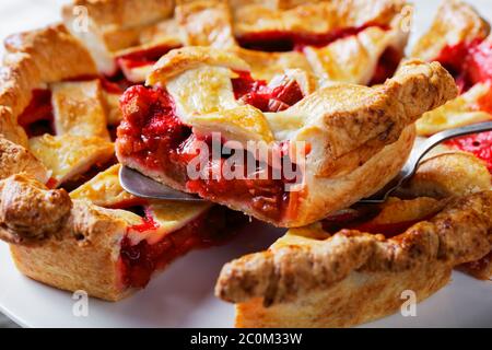 Nahaufnahme von frisch gebackenen hausgemachten Strawberry Rhabarb Pie Scheiben auf einem weißen Kuchenteller Stockfoto