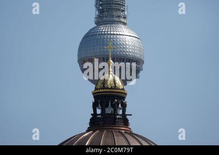 Berlin, Deutschland. Juni 2020. Die Spitze der Kuppel mit Kreuz ist auf dem Neubau des Berliner Schlosses, dem Humboldt Forum, vor dem Fernsehturm am Alexanderplatz (im Hintergrund) zu sehen. Quelle: Jörg Carstensen/dpa/Alamy Live News Stockfoto