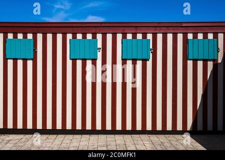 Die Sonne scheint auf einer bunt bemalten Holzwand Stockfoto