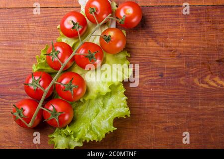 Frische, reife Kirschtomaten auf einem alten Holz Stockfoto