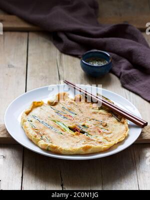 Traditionelle koreanische Krapfen mit grünen Zwiebeln und Chili, serviert mit Sojasauce. Stockfoto