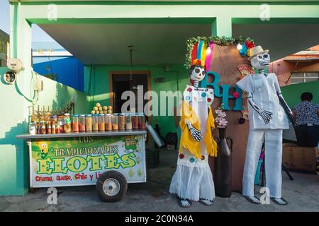 Merida, Mexiko - 31. Oktober 2018: Food steht für 'Elotes', was Mais mit Dekoration von Catrina Puppen für den Tag des Toten-Festivals bedeutet Stockfoto