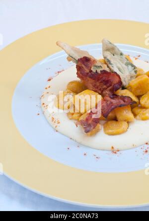 Gnocchi mit Kürbis und Erdnussbutter und knusprigem Speck Stockfoto